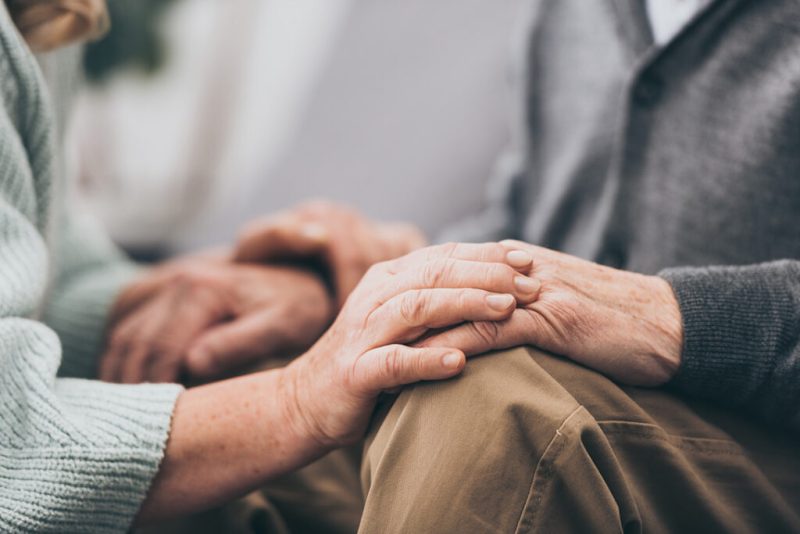 elderly hands holding in a caring environment